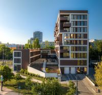 The building with large windows and greenery is located on Mierová Street in Bratislava.