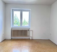 A room in a family house with a window, a radiator, and a floor with a wooden decor.