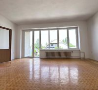 Living room in a family house with a large window and a wooden decor floor.