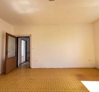 A room in a family house with a carpet and open doors, white walls.