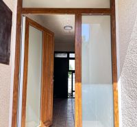 Entrance door with a wood decor leading to a family house, also visible is ceramic tiling.