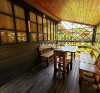 The terrace of the cottage in Prašice with wooden seating and a view of the garden.