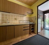 A kitchen in a cottage with a countertop, sink, and a view of the terrace with a wooden decor.