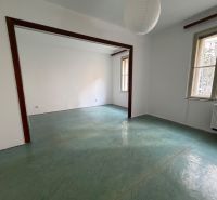 Empty room in a 3-room apartment with large windows and a green floor.