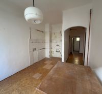A kitchen in a 3-room apartment with white walls and a floor with a wood decor.