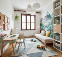 Children's room with a desk, sofa, toys, and a floor with a wooden decor.