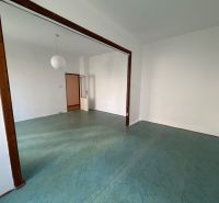 An empty room in a 3-room apartment with a floor featuring a green design and a white chandelier.