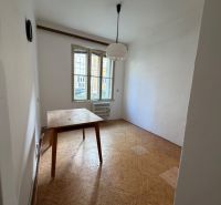 Dining room with wood-patterned flooring in a 3-room apartment, table and chandelier.