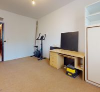 A room with an exercise bike, a table, and a wardrobe in a 3-room apartment.