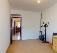 A room in a 3-room apartment with a desk and a stationary bike.