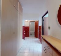 Hallway of a 3-room apartment with tiles, built-in wardrobes, and a mirror on the wall.