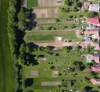 Aerial view of gardens and fields in Hruboňovo surrounded by greenery.