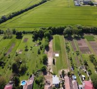An aerial view of the gardens in Hruboňovo, surrounded by green fields and trees.