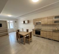A kitchen with wooden decor in a 3-room apartment with a dining table.