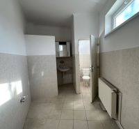 A hallway with light tiles and a view of the toilet in a 3-room apartment.