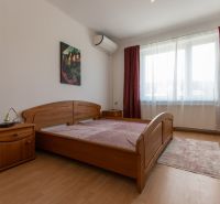 A bedroom with a wooden bed, nightstand, and floor with a wooden decor.