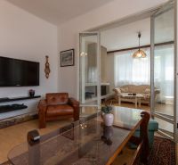 A living room in a 3-room apartment with leather sofas and a TV on the wall.