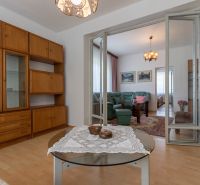Living room in a 3-room apartment with a green sofa and furniture with a wooden decor.