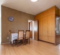 Dining area in a 3-room apartment with a wood-patterned floor and built-in wardrobes.