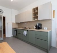 A kitchen in a 3-room apartment with a modern kitchen unit and a coffee maker.