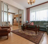 Living room in a 3-room apartment with a wooden decor floor and a folding wall.