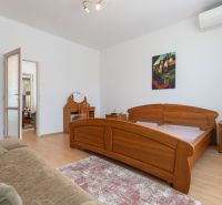 A bedroom in a 3-room apartment with wooden furniture and a floor with a wood decor.