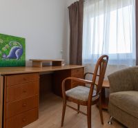 A desk with a chair and a painting in a 3-room apartment, floor with wooden decor.