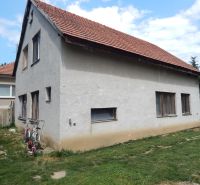A family house in Strekov with a brick roof and two bicycles by the wall.