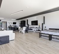 A spacious living room with wood-patterned flooring in a two-room apartment.