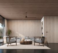 Bright living room in a villa with sofas, ceiling fan, and wood-patterned flooring.