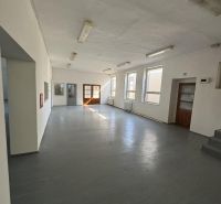 Commercial premises with multiple windows and a gray floor without decor.