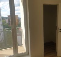 A room in a one-bedroom apartment with a balcony and a floor with a wood decor.