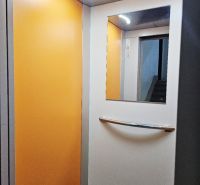 Interior of an elevator with orange walls and a mirror, 3-room apartment.