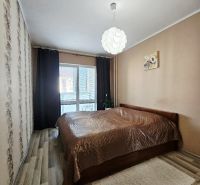 Bedroom with a bed and ceiling light in a 3-room apartment with wood-decor flooring.