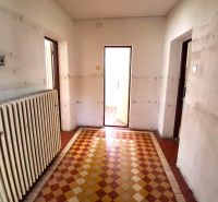 The interior of a family house with a radiator and checkered tile flooring.