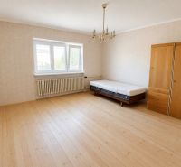 A room in a family house with a bed, a wardrobe, and a floor with a wooden decor.