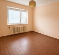 An empty room with a wooden floor and a white radiator.