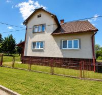 A family house in Sebechleby with a grassy plot and a woven fence.