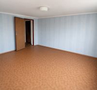 A room in a family house with wallpaper and a wooden decor floor.