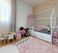 Children's room in a three-room apartment with a wooden decor floor and wall decorations.
