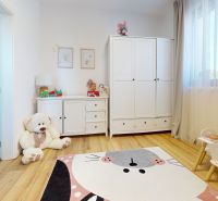 Children's room with a wardrobe, toys, and a floor with a wooden decor in a 3-room apartment.
