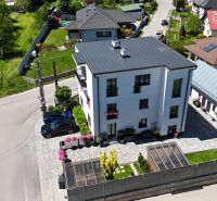 The building on Banská Street in Banská Bystrica, surrounded by a garden and a driveway.