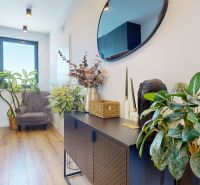 Interior of a 3-room apartment with a wooden decor floor, houseplants, decorations.