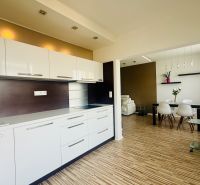 A kitchen with a dining area in a 3-room apartment, with a wooden decor floor.