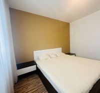 Bedroom in a 3-room apartment with a bed and a wooden decor floor.