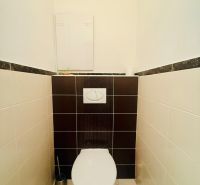 A toilet in a 3-room apartment with contrasting tiles.