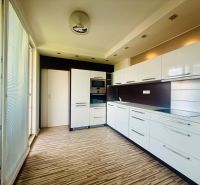 A kitchen in a 3-room apartment with white cabinets and a wooden decor floor.