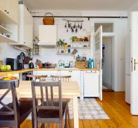 A kitchen in a 3-room apartment with a wooden decor floor and rustic elements.