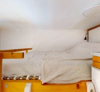 Bunk bed with wooden elements and white bedding in a 3-room apartment.