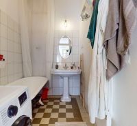 Bathroom in a 3-room apartment, equipped with a washing machine, bathtub, and sink.